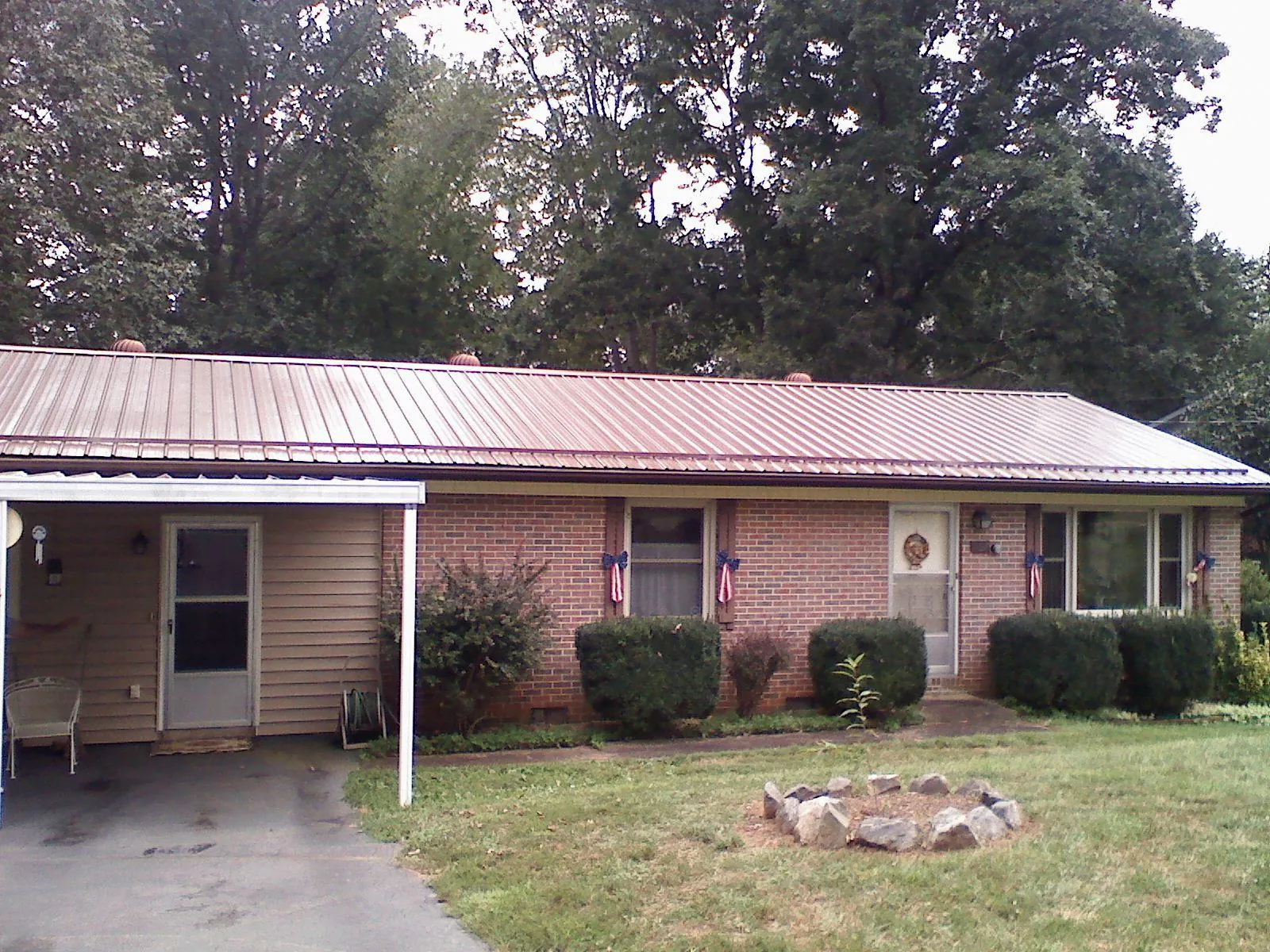 Bronze metal roof and carport on a brick ranch home — Roof Repair work by our crew in Otho